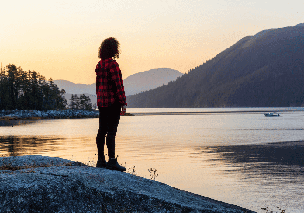 Person standing peacefully by water representing healthy boundaries in eating disorder recovery