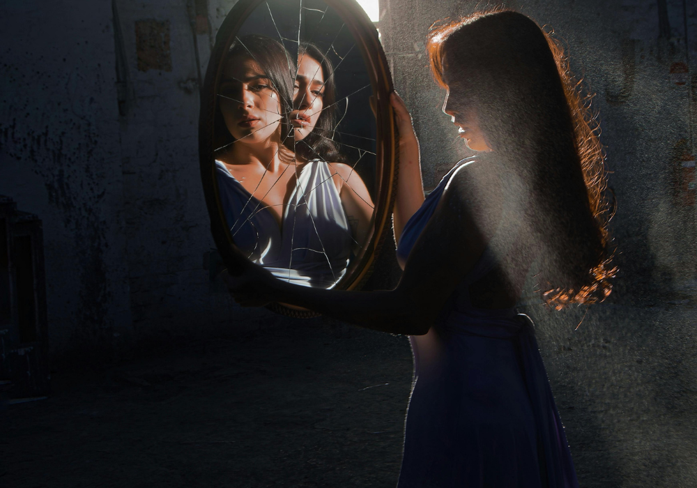 A person gazing introspectively into a mirror, symbolizing the distorted perception of reality often found in both eating disorder patterns and toxic relationships.